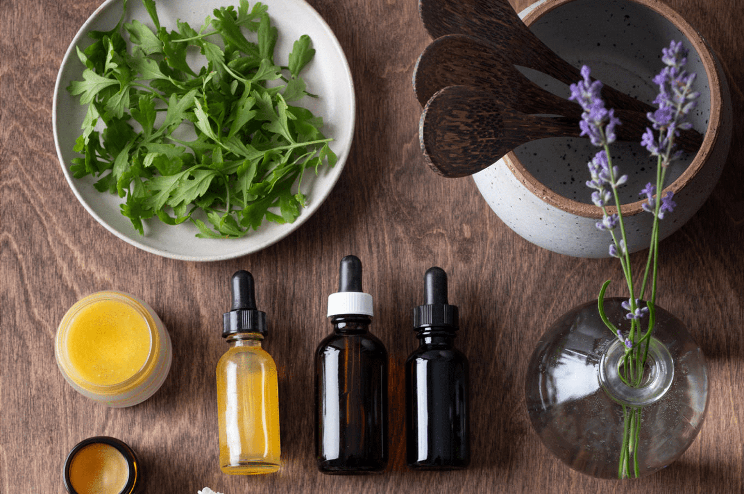 Herbs, oils, and lavender on wooden table.