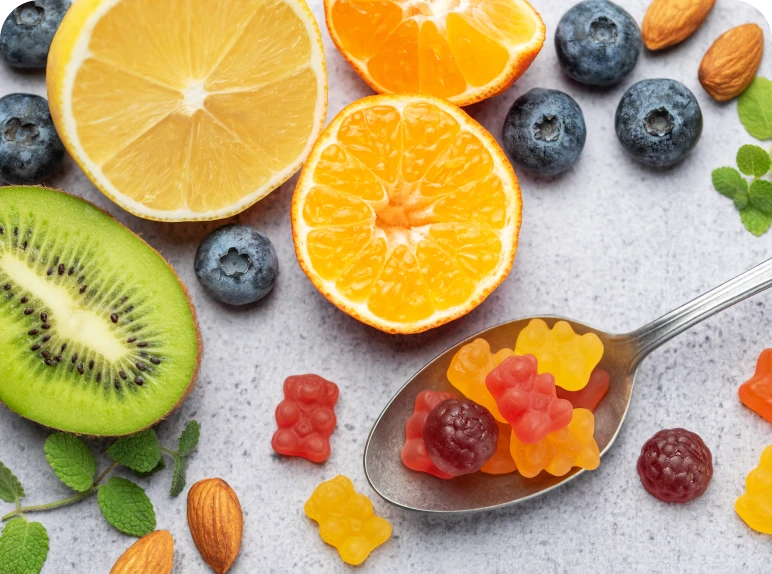 Fruits and gummies on a spoon.
