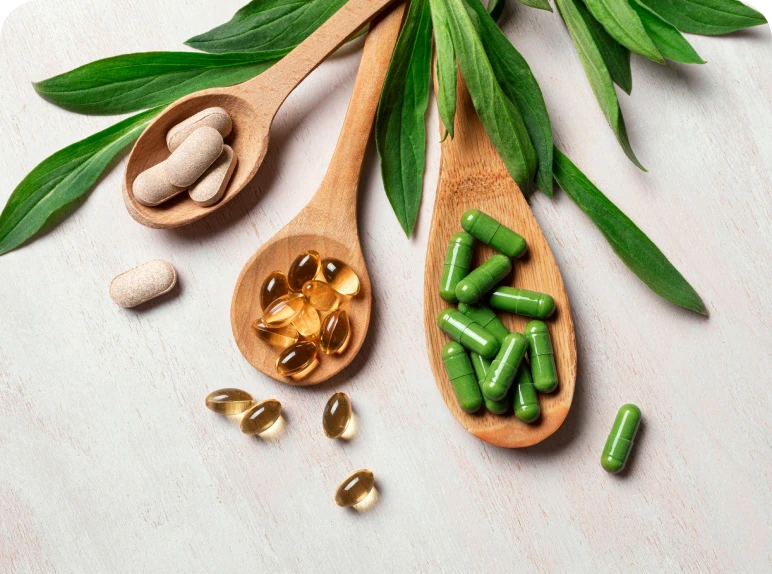 Wooden spoons with supplements and leaves.